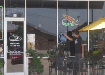 Pizza Restaurant Exterior | Man Tending Plants | Mogio's Pizza Red Oak, TX